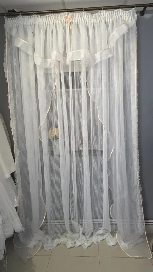 perdea elegantă, confecționată dintr-un material alb, transparent și fin, ideal pentru decorul ferestrelor.